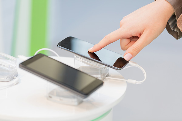 Unrecognizable person examining smart phone in electronics store