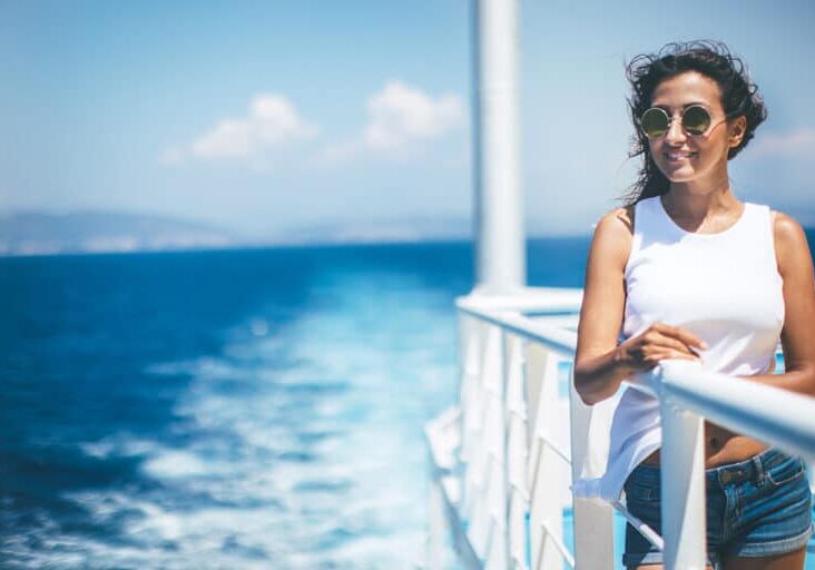 Young woman on windy cruise ship