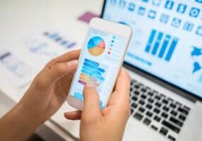 Close up of unrecognizable woman using an app looking at statistics - **DESIGN ON SCREENS WERE MADE FROM SCRATCH BY US**